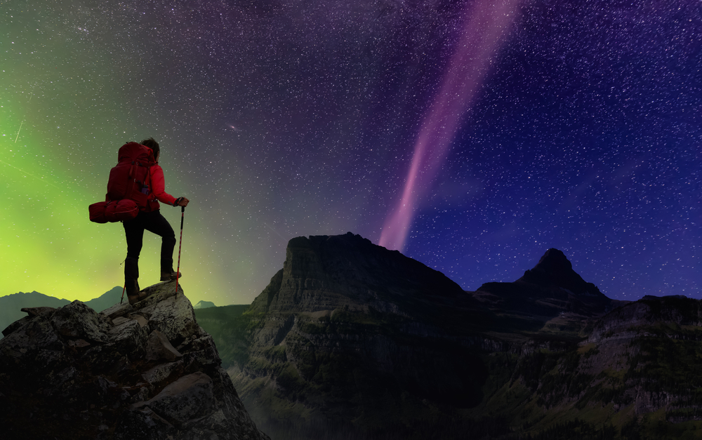 Girl Hiking on top of Rocky Mountains with backpack