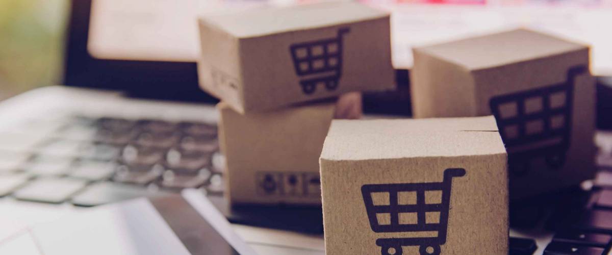 Online shopping - Paper cartons or parcel with a shopping cart logo and credit card on a laptop keyboard. Shopping service on The online web and offers home delivery.